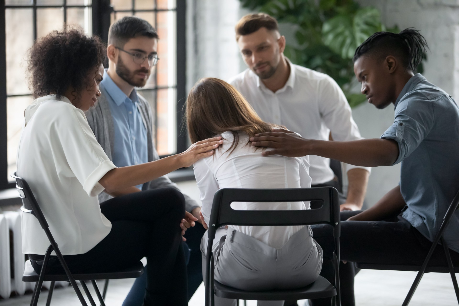 Personas diversas de apoyo consuelan a la mujer infeliz en la sesión